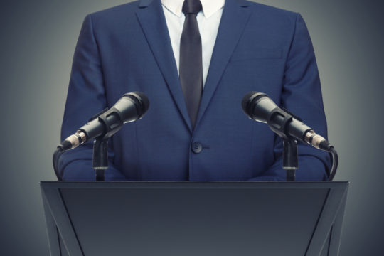 Man making a speech from behind a pulpit