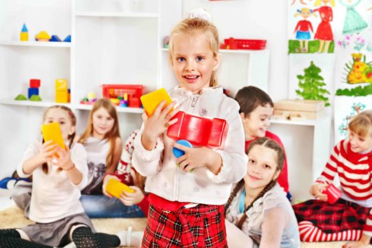 Young girl standing holding building blocks