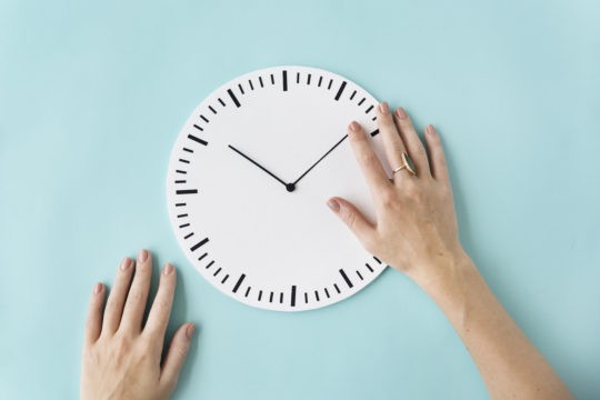 A clock with a lady’s hand moving the hands