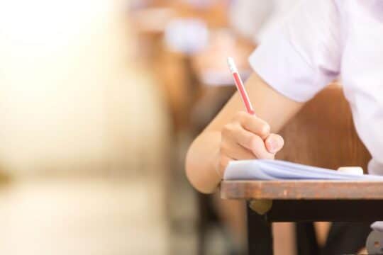 A close-up of a students hand and their pencil grip.