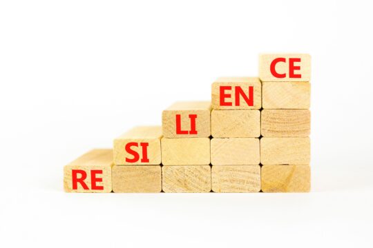 Building blocks forming stairs going upward say, “resilience.”