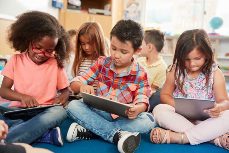 A group of students sit together using edtech tools on iPads.