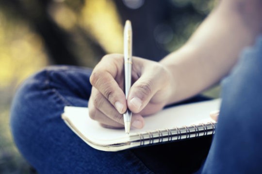 Close up of a boy writing in his notebook