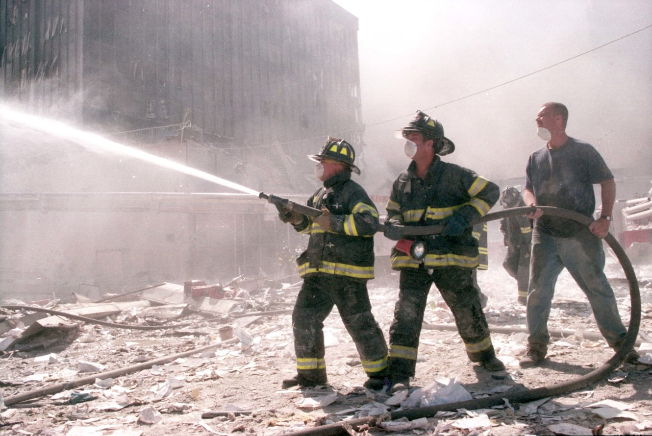 Firefighters spraying hose to put out a fire