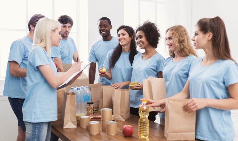 Group of older students packing bags of food for a food drive.