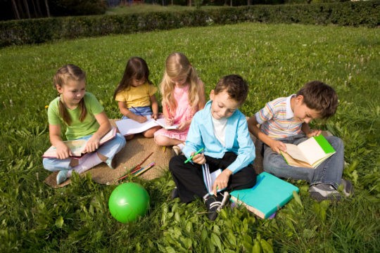 A group of young students sitting outside with books