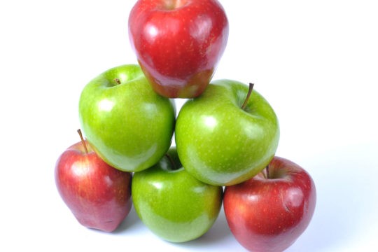 A stack of red and green apples formed into a pyramid