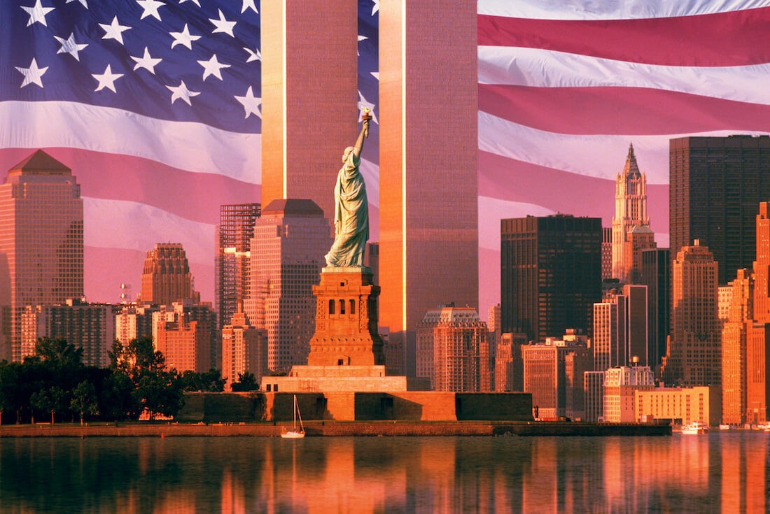 Statue of liberty and world trade center with American flag in background