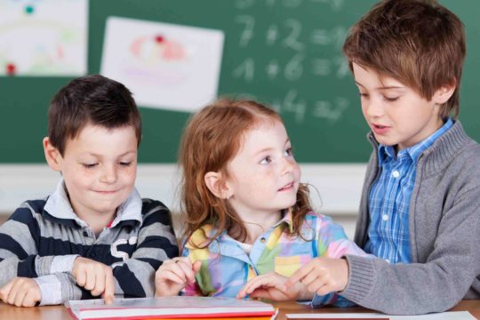 Three young students working together on math problems