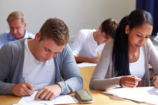 Two high school students at a desk writing