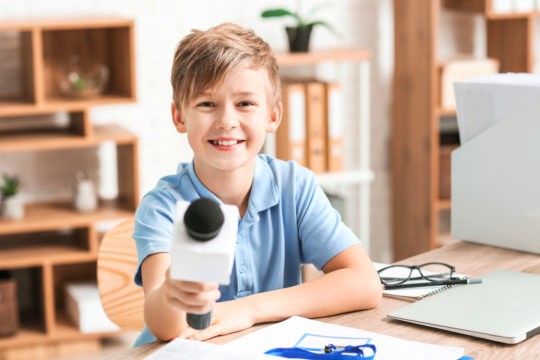 Young boy smiling and holding a microphone