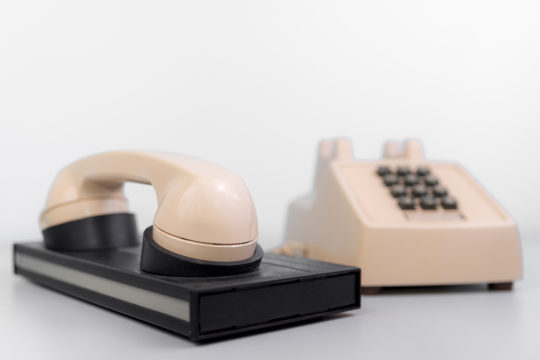 An old phone sitting on top of an internet modem