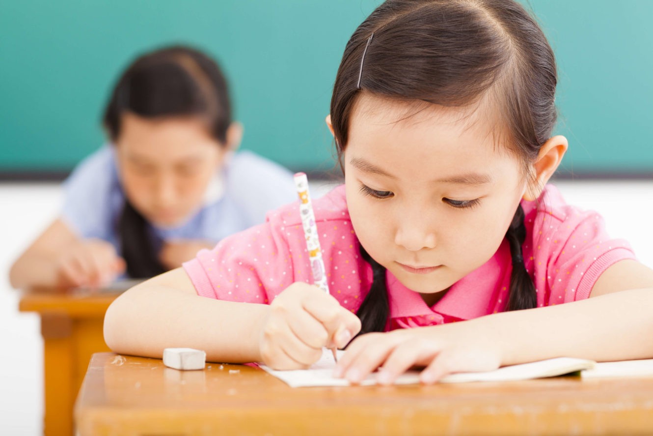 Young girl writing at her desk