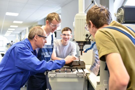 A group of students watch their teacher demonstrate in technical vocational training.