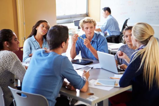 Group of high school students working together at a table.