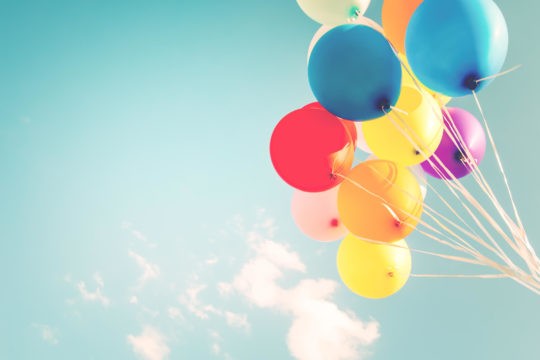 A group of colorful balloons floating up in the sky