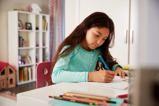 Young girl at desk working on homework