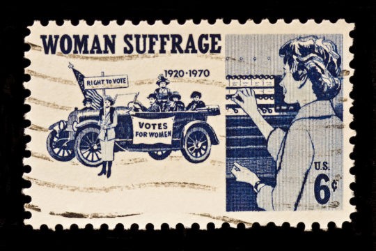 An old stamp showing women protesting against inequality and fighting for their right to vote